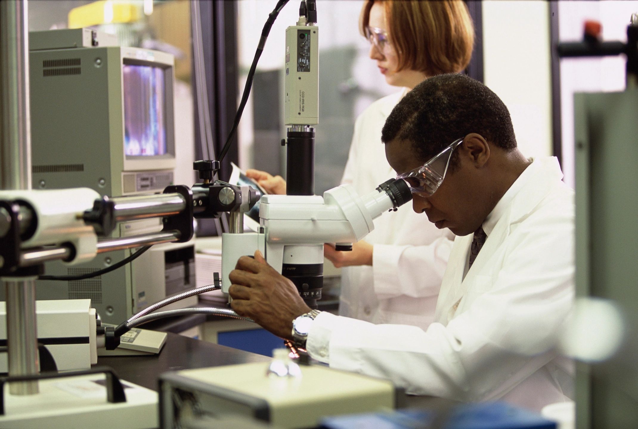 Scientists in lab using microscope