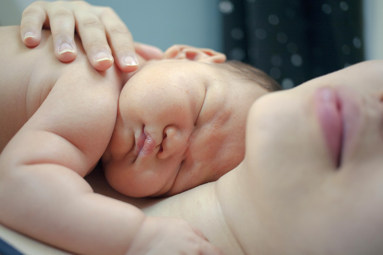 Infant sleeping on adult's chest.